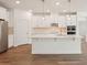 Bright, modern kitchen features white cabinets, stainless steel appliances and wood-look tile flooring at 466 Sun Chaser Dr, Nokomis, FL 34275