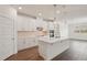 Bright, modern kitchen features white cabinets, stainless steel appliances and wood-look tile flooring at 466 Sun Chaser Dr, Nokomis, FL 34275