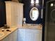 Bathroom featuring a vanity with ample cabinet space, an oval mirror, and a glass-enclosed shower at 3233 Purple Martin Dr # 121, Punta Gorda, FL 33950