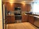 Functional kitchen featuring stainless steel appliances, warm wood cabinets, granite countertops, and tiled backsplash at 3233 Purple Martin Dr # 121, Punta Gorda, FL 33950