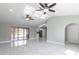 Open-concept living room featuring sleek tile flooring, ceiling fans, and sliding glass doors to the outdoors at 1147 Yachtsman Ln, Punta Gorda, FL 33983