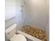 Modern bathroom featuring tiled walls, pebble flooring, and a sleek, wall-mounted shower system at 2956 Laurel Ct, Dunedin, FL 34698