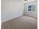 Cozy bedroom with neutral carpet, ample natural light from the window, and a ceiling fan at 2956 Laurel Ct, Dunedin, FL 34698
