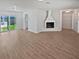 Spacious living room with wood-look floors and a fireplace, offering plenty of natural light at 2956 Laurel Ct, Dunedin, FL 34698