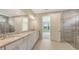 Elegant bathroom showcasing dual sinks, granite countertops, and a glass-enclosed shower at 14451 Coastal Woodland Ln, Parrish, FL 34219