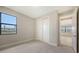 Bedroom showcasing neutral walls, plush carpeting, closet and a window with scenic views at 14451 Coastal Woodland Ln, Parrish, FL 34219