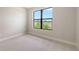 Cozy bedroom featuring a large window overlooking natural scenery at 14451 Coastal Woodland Ln, Parrish, FL 34219