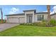 Beautiful single-story home with a manicured lawn, attached garage, and lovely landscaping at 14451 Coastal Woodland Ln, Parrish, FL 34219