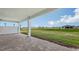 Covered outdoor patio with brick flooring and a serene view of the green lawn at 14451 Coastal Woodland Ln, Parrish, FL 34219