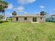 Spacious backyard with lush green grass and a view of the home's exterior at 3593 Junction St, North Port, FL 34288