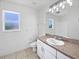 Bright bathroom features white cabinets, a sink, large mirror, and a window for natural light at 3593 Junction St, North Port, FL 34288