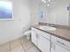 Bright bathroom with white cabinets, a sink, large mirror, and a toilet at 3593 Junction St, North Port, FL 34288