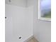 Clean, white tiled shower with updated fixtures and a bright window for natural light at 3593 Junction St, North Port, FL 34288