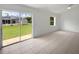 Bright, open bedroom boasts tile flooring, white walls, and glass patio doors opening to the backyard at 3593 Junction St, North Port, FL 34288