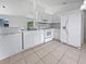 Bright kitchen featuring white appliances, countertops, and ample cabinet space at 3593 Junction St, North Port, FL 34288