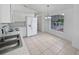 Eat-in kitchen with all-white appliances and tiled floor with abundant natural light at 3593 Junction St, North Port, FL 34288