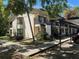 Two story condo building featuring a carport, stairs, and manicured landscaping with large mature trees at 11511 113Th St # 13F, Seminole, FL 33778
