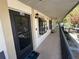 Exterior view of condo unit 13F, with a black door, overhead lighting, and a covered walkway at 11511 113Th St # 13F, Seminole, FL 33778