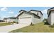 Light gray home showcasing a two-car garage and a manicured lawn at 2318 E Newsome Rd, Plant City, FL 33565