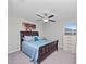 Bright bedroom with a wooden bed frame, white dresser, and colorful wall art at 13327 Willow Bluestar Loop, Riverview, FL 33579