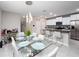 Open concept dining area with a glass table, modern pendant lighting, and views into the kitchen at 13327 Willow Bluestar Loop, Riverview, FL 33579