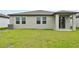This is a view of the back of the house, featuring a lush green lawn and large sliding glass doors at 225 Lazy Shore Dr, Nokomis, FL 34275