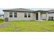 View of the backyard featuring a green lawn and the home's exterior at 225 Lazy Shore Dr, Nokomis, FL 34275