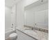 Bright bathroom with a single sink vanity, granite countertop and shower-tub combo at 225 Lazy Shore Dr, Nokomis, FL 34275