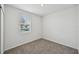 Cozy bedroom showcasing a window with blinds and plush gray carpeting at 225 Lazy Shore Dr, Nokomis, FL 34275