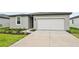 The exterior of the home features a two-car garage and simple landscaping at 225 Lazy Shore Dr, Nokomis, FL 34275