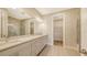 Well-lit bathroom with double vanity, modern fixtures, marble-look tiling and walk-in closet at 14517 Coastal Woodland Ln, Parrish, FL 34219