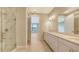 Bright bathroom featuring double vanity, Quartz countertops, and glass-enclosed walk-in shower at 14517 Coastal Woodland Ln, Parrish, FL 34219
