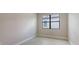 Empty bedroom with light-colored hard flooring and a black framed window at 14517 Coastal Woodland Ln, Parrish, FL 34219