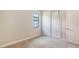 Neutral bedroom with carpet, closet with sliding doors, base trim, and a window with a black frame at 14517 Coastal Woodland Ln, Parrish, FL 34219