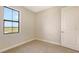 Bright, carpeted bedroom featuring a large window with a view at 14517 Coastal Woodland Ln, Parrish, FL 34219