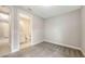 Bedroom with gray carpet leading to the doorframe to an ensuite bathroom and a glimpse of the hallway at 14517 Coastal Woodland Ln, Parrish, FL 34219