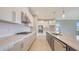 Modern kitchen showcasing white and grey cabinetry, stone countertops, and stainless steel appliances at 14517 Coastal Woodland Ln, Parrish, FL 34219