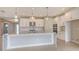 Spacious kitchen featuring white cabinets, a large island with a marble countertop, and stainless steel appliances at 14517 Coastal Woodland Ln, Parrish, FL 34219