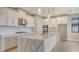 Bright kitchen featuring white cabinets, a large island with a marble countertop, and stainless steel appliances at 14517 Coastal Woodland Ln, Parrish, FL 34219