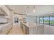 Bright kitchen featuring white cabinets, granite countertops, an island, and stainless steel appliances at 14517 Coastal Woodland Ln, Parrish, FL 34219