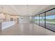 Open-concept living room with kitchen, tile flooring, and sliding glass doors to the outdoors at 14517 Coastal Woodland Ln, Parrish, FL 34219