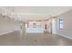 Open-concept living and kitchen area with island, stainless steel appliances, and modern light fixtures at 14517 Coastal Woodland Ln, Parrish, FL 34219