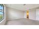 Bright main bedroom with tray ceiling, neutral walls, tile flooring, and ensuite bathroom access at 14517 Coastal Woodland Ln, Parrish, FL 34219