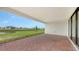 Paver patio overlooking a pond with manicured green grass and other new construction homes in the distance at 14517 Coastal Woodland Ln, Parrish, FL 34219