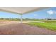 Paver patio overlooking a pond with manicured green grass and other new construction homes in the distance at 14517 Coastal Woodland Ln, Parrish, FL 34219