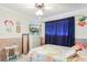 Bedroom with nautical decor, a dresser, and a window with blue curtains at 6540 Marius Rd, North Port, FL 34287