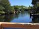 Scenic water view of the backyard canal, surrounded by trees at 6540 Marius Rd, North Port, FL 34287