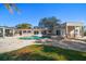 Expansive backyard showcasing a pool, spa, travertine tile, and outdoor entertaining areas at 103 Shore Dr, Dunedin, FL 34698
