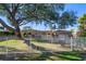 Lovely home showcasing a verdant lawn, mature trees, and a classic white picket fence at 103 Shore Dr, Dunedin, FL 34698