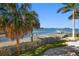Picturesque waterfront view featuring a private dock, lush landscaping, and clear blue water at 103 Shore Dr, Dunedin, FL 34698